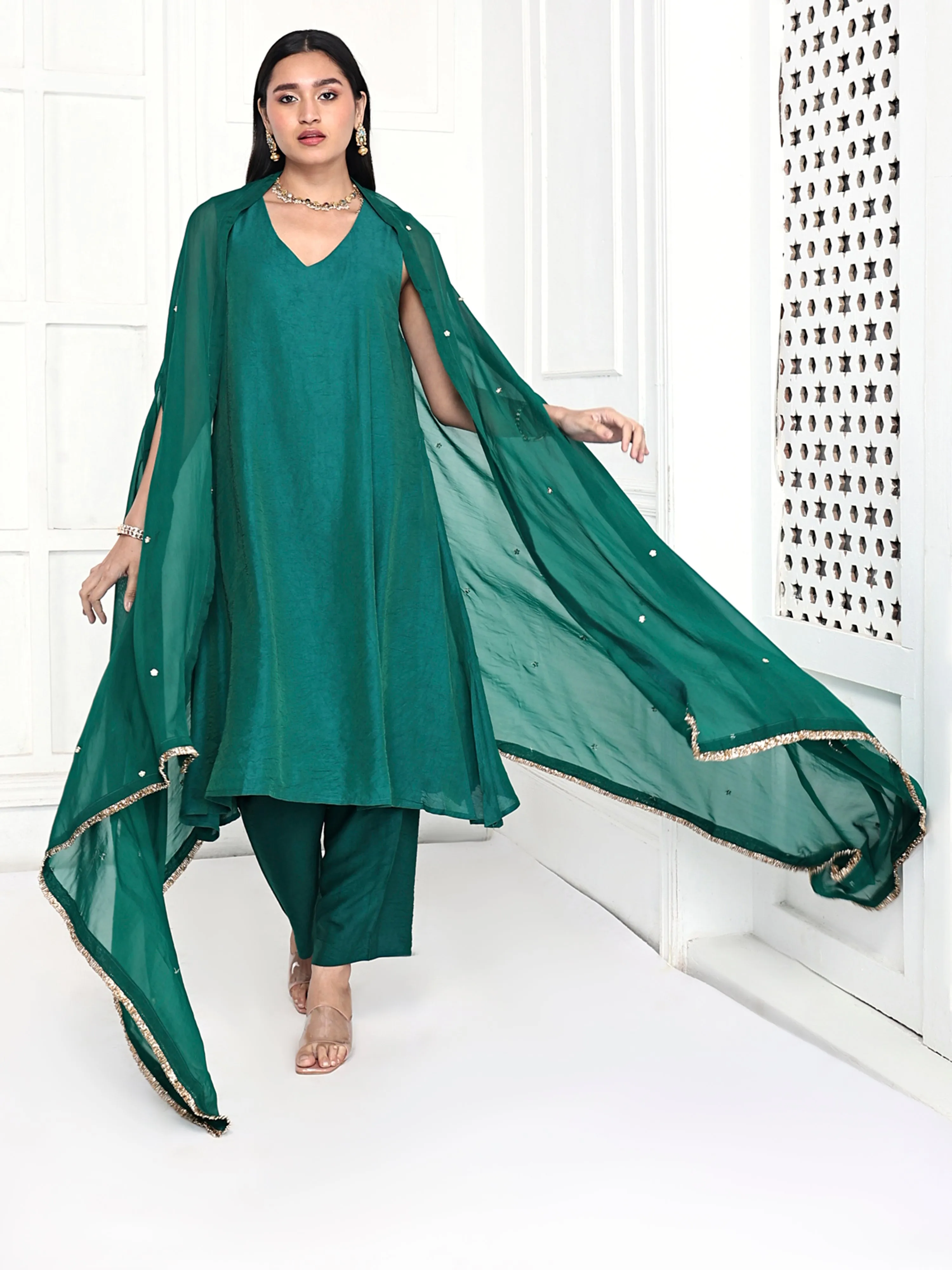 A line tunic paired with pants and embellished cape.